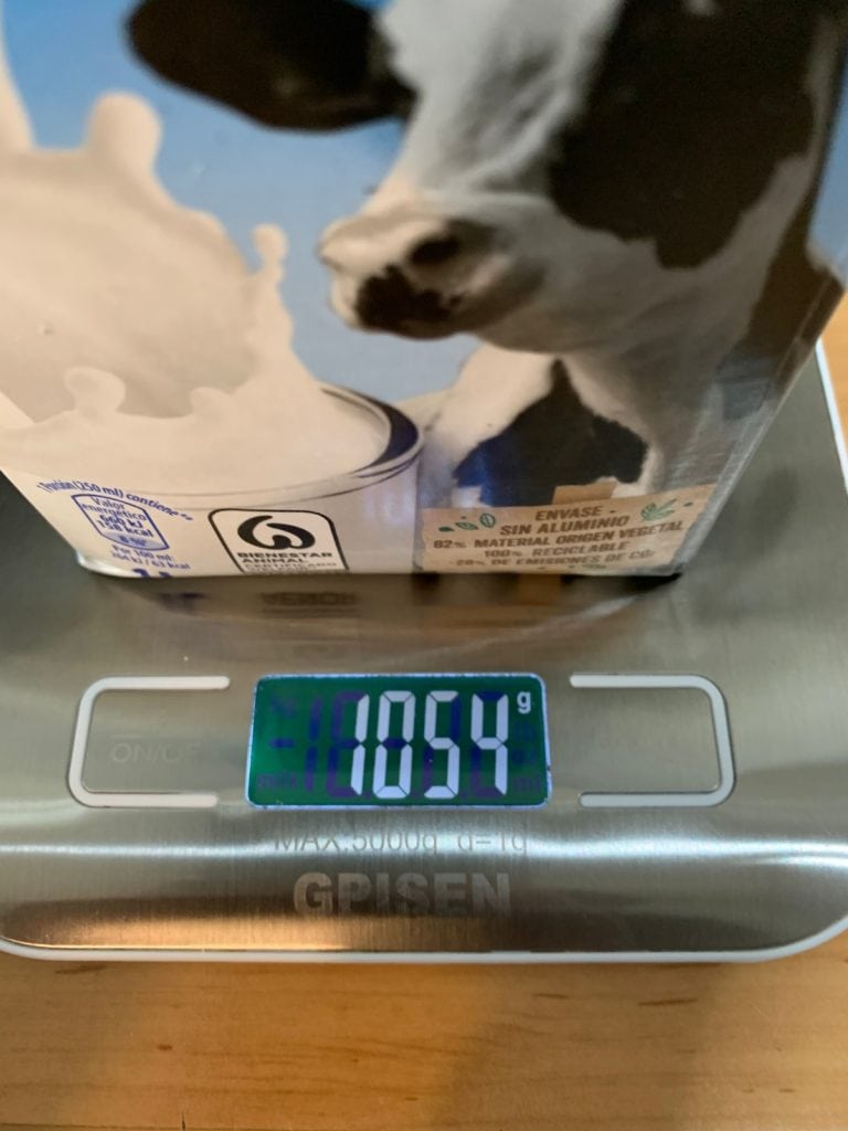 Pesando 1 litro de leche en balanza (1000 gramos aproximadamente igual a 1 litro)